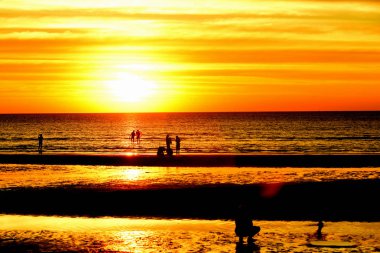 Gün batımında güzel sahil manzarasında birçok insan gün batımından önce oynamak için sahile gelirler..