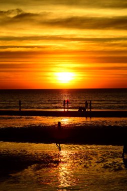 Gün batımında güzel sahil manzarasında birçok insan gün batımından önce oynamak için sahile gelirler..