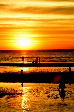 Gün batımında güzel sahil manzarasında birçok insan gün batımından önce oynamak için sahile gelirler..