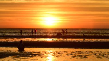 Gün batımında güzel sahil manzarasında birçok insan gün batımından önce oynamak için sahile gelirler..