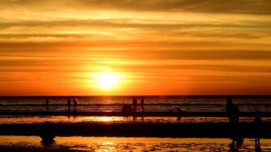 Gün batımında güzel sahil manzarasında birçok insan gün batımından önce oynamak için sahile gelirler..
