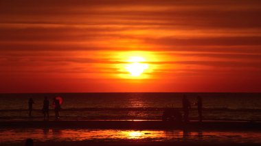 Gün batımında güzel sahil manzarasında birçok insan gün batımından önce oynamak için sahile gelirler..