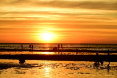 Gün batımında güzel sahil manzarasında birçok insan gün batımından önce oynamak için sahile gelirler..