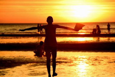 Gün batımında güzel sahil manzarasında birçok insan gün batımından önce oynamak için sahile gelirler..