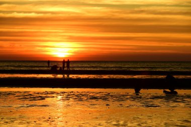 Gün batımında güzel sahil manzarasında birçok insan gün batımından önce oynamak için sahile gelirler..