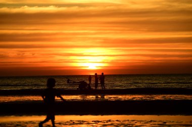 Gün batımında güzel sahil manzarasında birçok insan gün batımından önce oynamak için sahile gelirler..