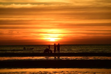 Gün batımında güzel sahil manzarasında birçok insan gün batımından önce oynamak için sahile gelirler..