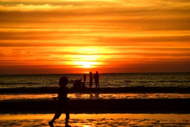 Gün batımında güzel sahil manzarasında birçok insan gün batımından önce oynamak için sahile gelirler..