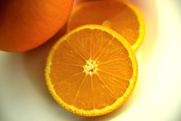 Orange, half of orange, orange lobule and basket with oranges on the wooden table on the green blurred background.Composition with variety of fruits.dieting concept,