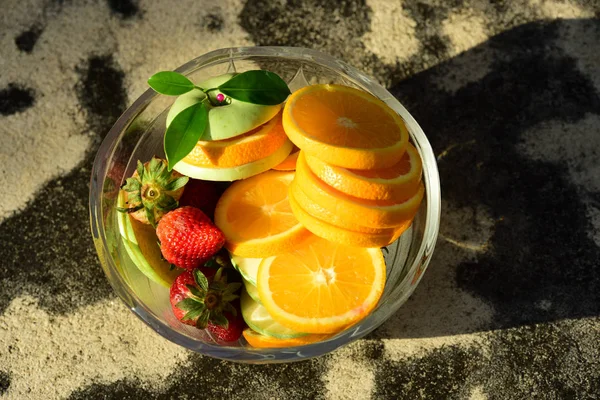 Orange, half of orange, orange lobule and basket with oranges on the wooden table on the green blurred background.Composition with variety of fruits.dieting concept,