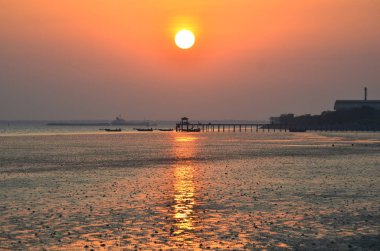 Günbatımını yansıtan gökyüzü ile deniz suyu