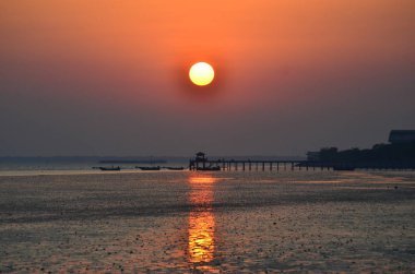 Günbatımını yansıtan gökyüzü ile deniz suyu