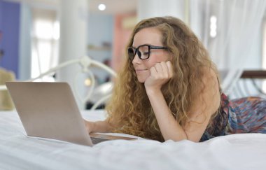 Genç Seksi güzel ve mutlu kadın portresi ben dizüstü kullanma ve yalan bikini. Güzellik kadını çekici ile gülümseme ve sağlık cilt ve saç, tatlı bir gülümsemeyle kadınla güzel bir şey göstermek
