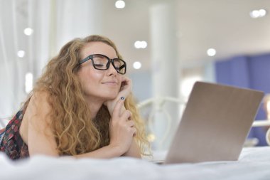 Genç Seksi güzel ve mutlu kadın portresi ben dizüstü kullanma ve yalan bikini. Güzellik kadını çekici ile gülümseme ve sağlık cilt ve saç, tatlı bir gülümsemeyle kadınla güzel bir şey göstermek