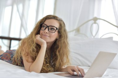 Genç Seksi güzel ve mutlu kadın portresi ben dizüstü kullanma ve yalan bikini. Güzellik kadını çekici ile gülümseme ve sağlık cilt ve saç, tatlı bir gülümsemeyle kadınla güzel bir şey göstermek