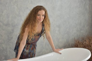 Bathtub.relaxed zamanında banyo döşeme genç bir kadın portresi. Güzel kadın. Güzel bir kızın beyaz pijamalı portre rahatlatıcı ile rahat bir tatil