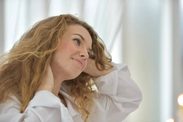 The act of women With gestures When she wakes up In the morning, in white pajamas.