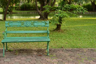 Güzel parktaki yeşil bankta.