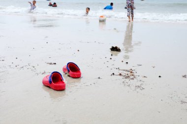 Kumlu sahil yüzeyinde ayakkabılar, Tayland