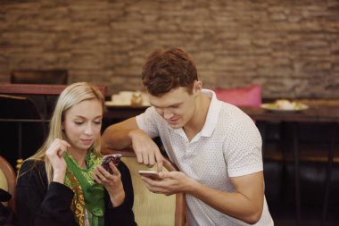 Kadın ve erkek cep telefonu kullanıyor.