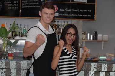 Mutlu çift tezgahın önünde duruyor.