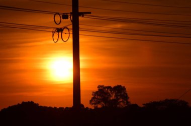 günbatımı arka planında elektrik direği silueti 