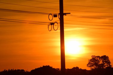 günbatımı arka planında elektrik direği silueti 