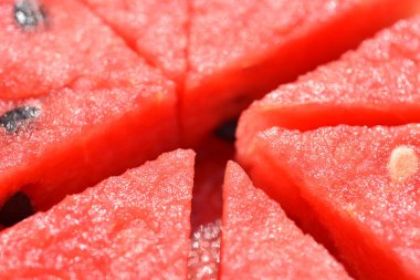 Kırmızı kavun eti, bölümleri desenleri ve tohum kullanılmış bir arka plan görüntüsü olarak kesilmiş.