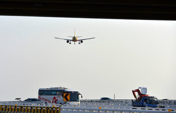 The plane is flying into the airport to land at Suvarnabhumi Airport. Thailand. The plane is tilting to turn into the airport. Landing commercial airplane