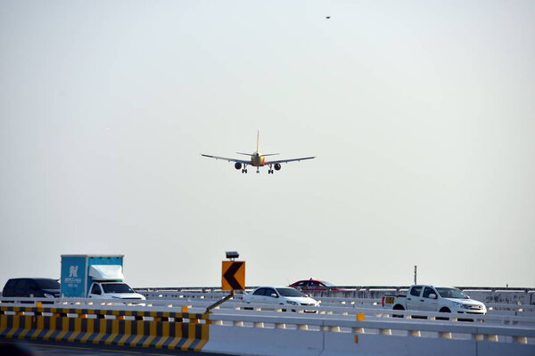 The plane is flying into the airport to land at Suvarnabhumi Airport. Thailand. The plane is tilting to turn into the airport. Landing commercial airplane.