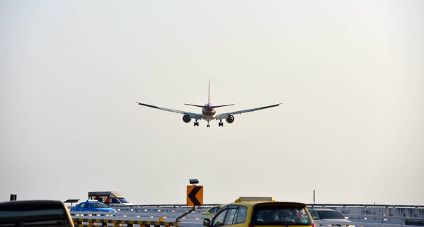 The plane is flying into the airport to land at Suvarnabhumi Airport. Thailand. The plane is tilting to turn into the airport. Landing commercial airplane.