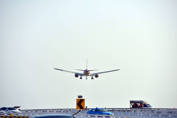 The plane is flying into the airport to land at Suvarnabhumi Airport. Thailand. The plane is tilting to turn into the airport. Landing commercial airplane.