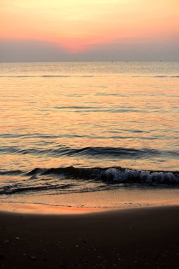 Sabah ın erken saatlerinde plaj manzarası Şezlong ile güneş doğarken altın sarısı gökyüzü ve güneş