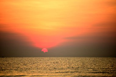 Sabah ın erken saatlerinde plaj manzarası Şezlong ile güneş doğarken altın sarısı gökyüzü ve güneş