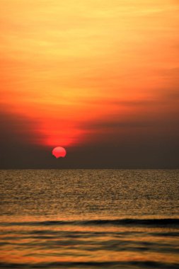 Yükselen güneş manzarası ve plaj. Güzel altın sarısı gökyüzü ve plaj, plaj ve şezlong güneşlenme görünümü yükseliyor. Güzel altın sarıgökyüzü ve güneş