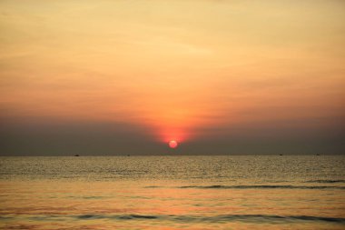 Sabah ın erken saatlerinde plaj manzarası Şezlong ile güneş doğarken altın sarısı gökyüzü ve güneş