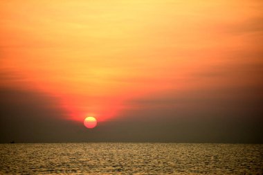 Yükselen güneş manzarası ve plaj. Güzel altın sarısı gökyüzü ve plaj, plaj ve şezlong güneşlenme görünümü yükseliyor. Güzel altın sarıgökyüzü ve güneş