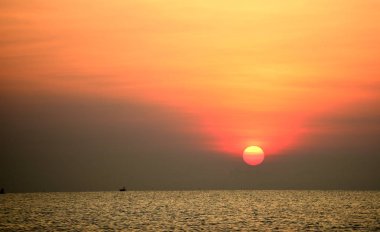 Yükselen güneş manzarası ve plaj. Güzel altın sarısı gökyüzü ve plaj, plaj ve şezlong güneşlenme görünümü yükseliyor. Güzel altın sarıgökyüzü ve güneş