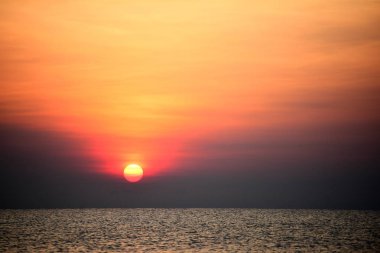 Yükselen güneş manzarası ve plaj. Güzel altın sarısı gökyüzü ve plaj, plaj ve şezlong güneşlenme görünümü yükseliyor. Güzel altın sarıgökyüzü ve güneş