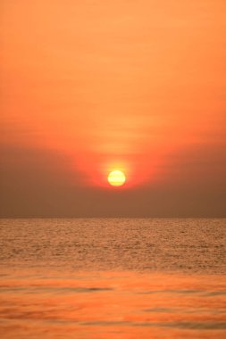 Yükselen güneş manzarası ve plaj. Güzel altın sarısı gökyüzü ve plaj, plaj ve şezlong güneşlenme görünümü yükseliyor. Güzel altın sarıgökyüzü ve güneş