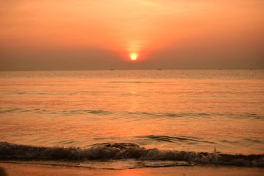 Sabah ın erken saatlerinde plaj manzarası Şezlong ile güneş doğarken altın sarısı gökyüzü ve güneş