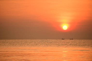 Sabah ın erken saatlerinde plaj manzarası Şezlong ile güneş doğarken altın sarısı gökyüzü ve güneş
