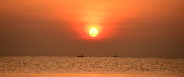 Yükselen güneş manzarası ve plaj. Güzel altın sarısı gökyüzü ve plaj, plaj ve şezlong güneşlenme görünümü yükseliyor. Güzel altın sarıgökyüzü ve güneş