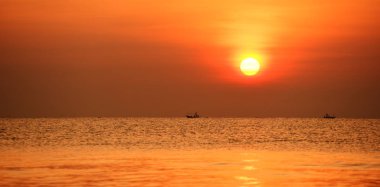 Yükselen güneş manzarası ve plaj. Güzel altın sarısı gökyüzü ve plaj, plaj ve şezlong güneşlenme görünümü yükseliyor. Güzel altın sarıgökyüzü ve güneş