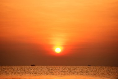Yükselen güneş manzarası ve plaj. Güzel altın sarısı gökyüzü ve plaj, plaj ve şezlong güneşlenme görünümü yükseliyor. Güzel altın sarıgökyüzü ve güneş