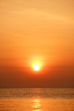 Sabah ın erken saatlerinde plaj manzarası Şezlong ile güneş doğarken altın sarısı gökyüzü ve güneş