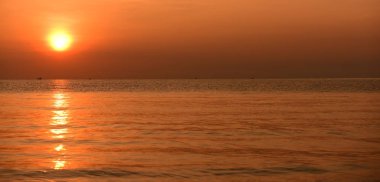 Sabah ın erken saatlerinde plaj manzarası Şezlong ile güneş doğarken altın sarısı gökyüzü ve güneş