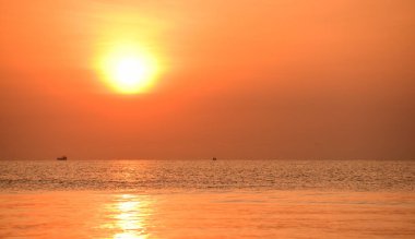 Sabah ın erken saatlerinde plaj manzarası Şezlong ile güneş doğarken altın sarısı gökyüzü ve güneş