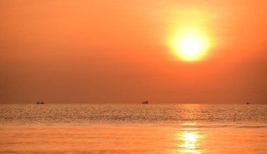 Sabah ın erken saatlerinde plaj manzarası Şezlong ile güneş doğarken altın sarısı gökyüzü ve güneş