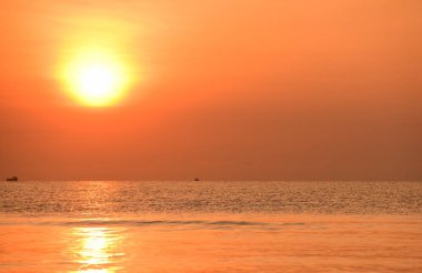 Sabah ın erken saatlerinde plaj manzarası Şezlong ile güneş doğarken altın sarısı gökyüzü ve güneş